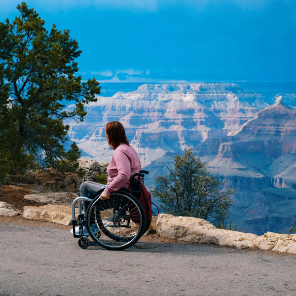A woman in a wheelchair on a path overlooking the Grand Canyon